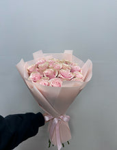 Woman holding pink roses bouquet in feminine shades