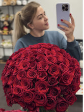 Woman holding 100 red roses Centennial Elegance bouquet
