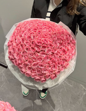 100 pink roses arranged in round wrapping presentation flowers station