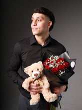 Man holding Midnight Elegance red roses bouquet in black wrapping