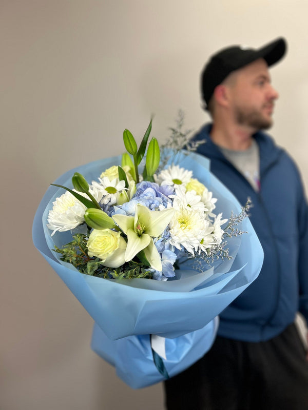 White lilies, blue hydrangea, white chrysanthemums, daisies and roses in light blue wrap — Flowers Station Winnipeg
